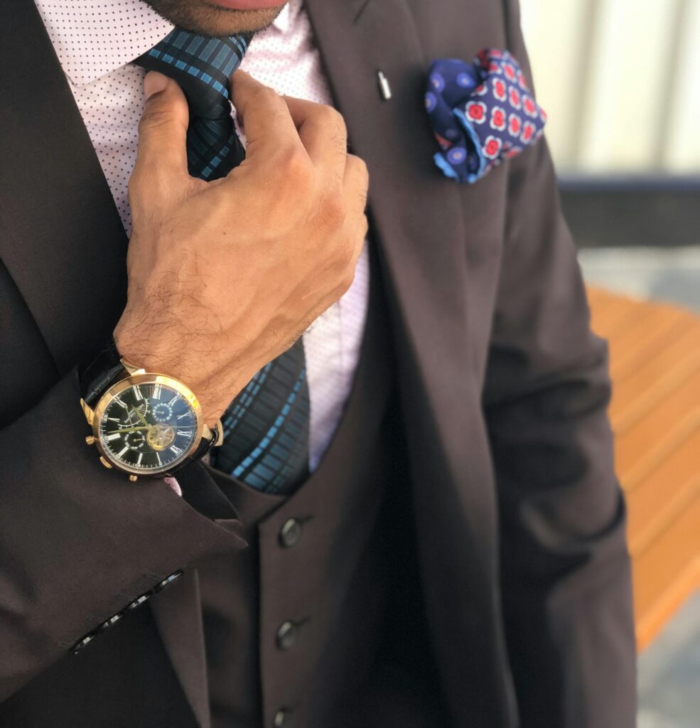 pexels photo 1342609 1342609 Elegant close-up of a man in a designer suit adjusting his tie, showcasing luxury fashion.